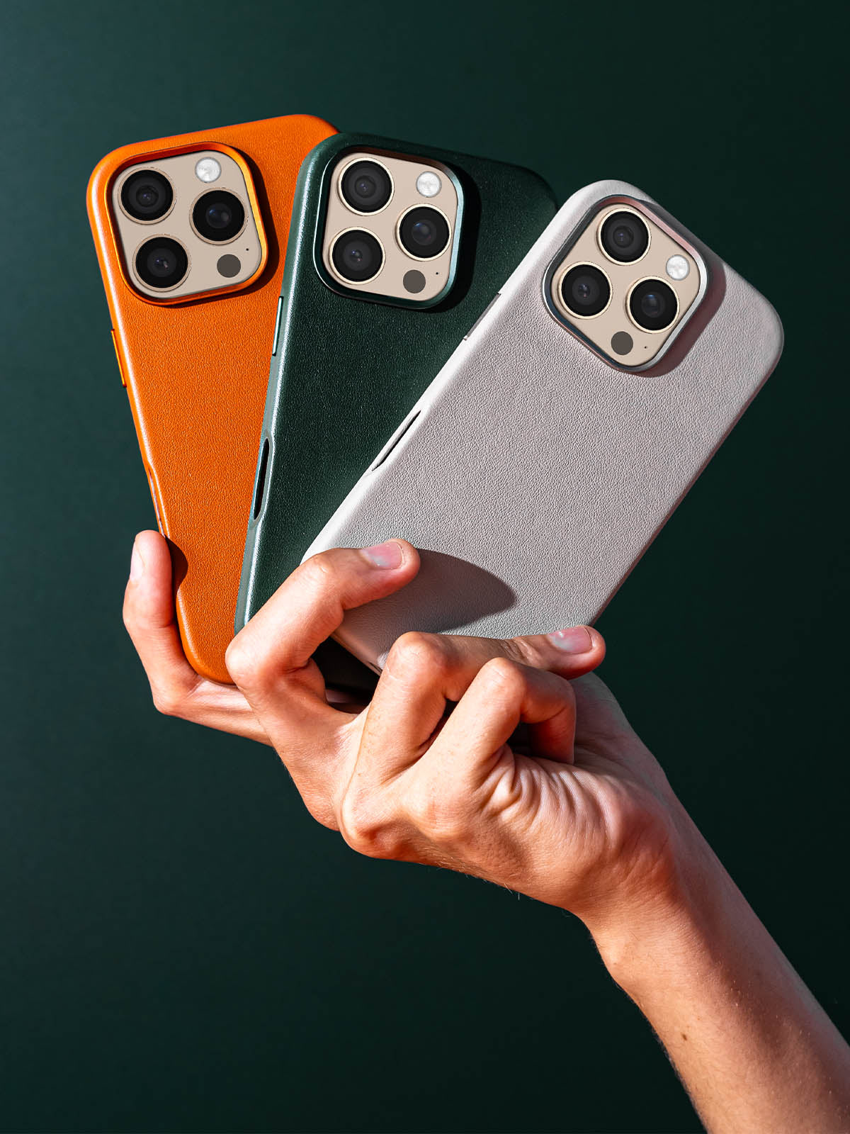 Timeless Luxe leather phone case in three different colors held in one hand