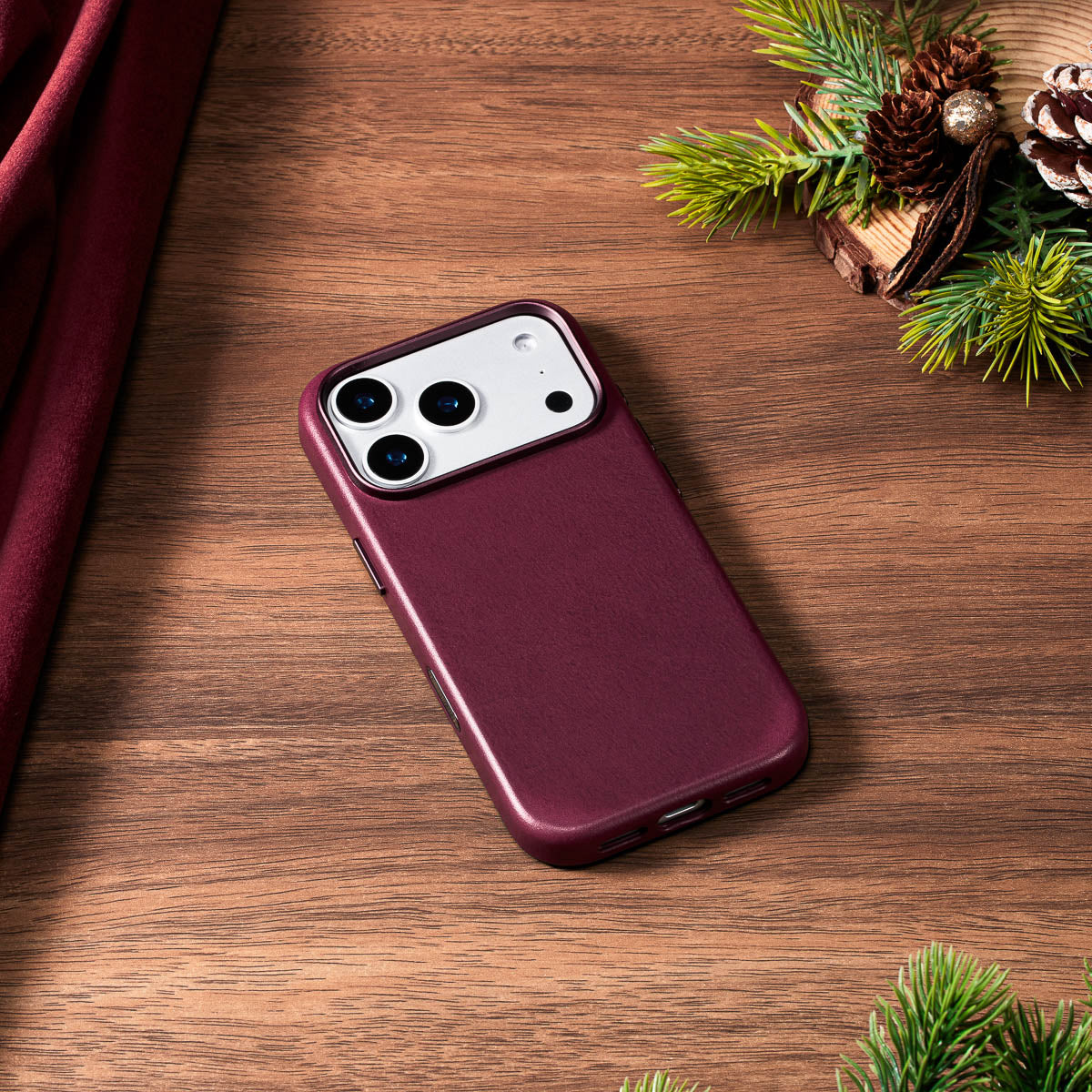 burgundy vachetta leather iphone 18 pro case lying flat on wooden desk