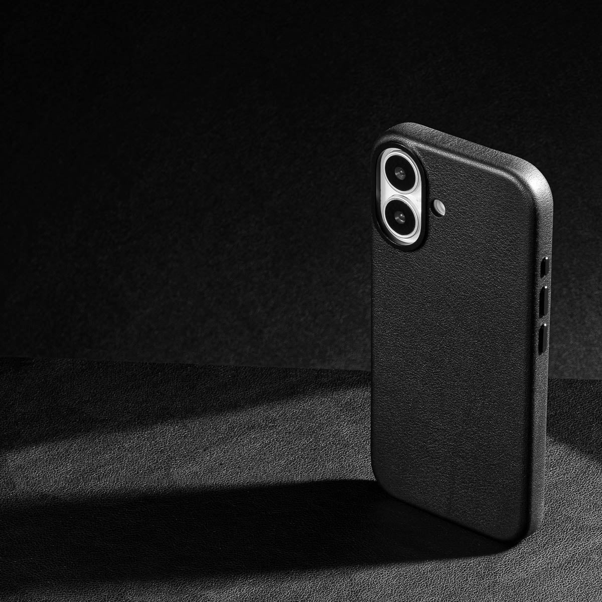 iphone 17 leather case in obsidian black - raised camera ring and colour matched metal buttons detailing