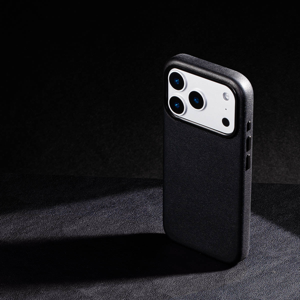 iphone 17 pro leather case in obsidian black - raised camera ring and colour matched metal buttons detailing