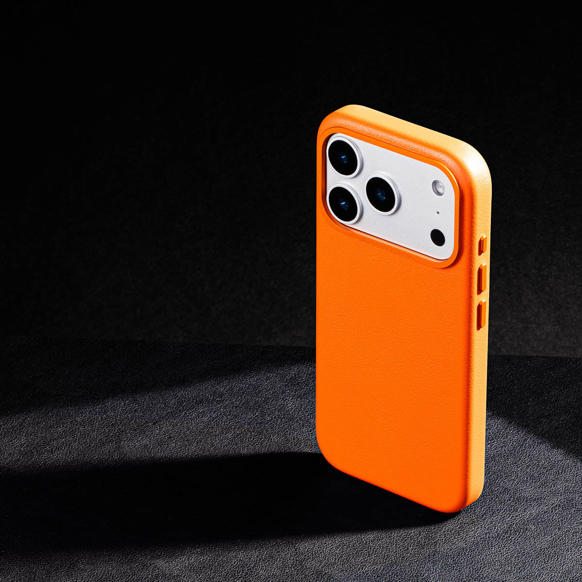 iphone 17 pro leather case in solar orange - raised camera ring and colour matched metal buttons detailing