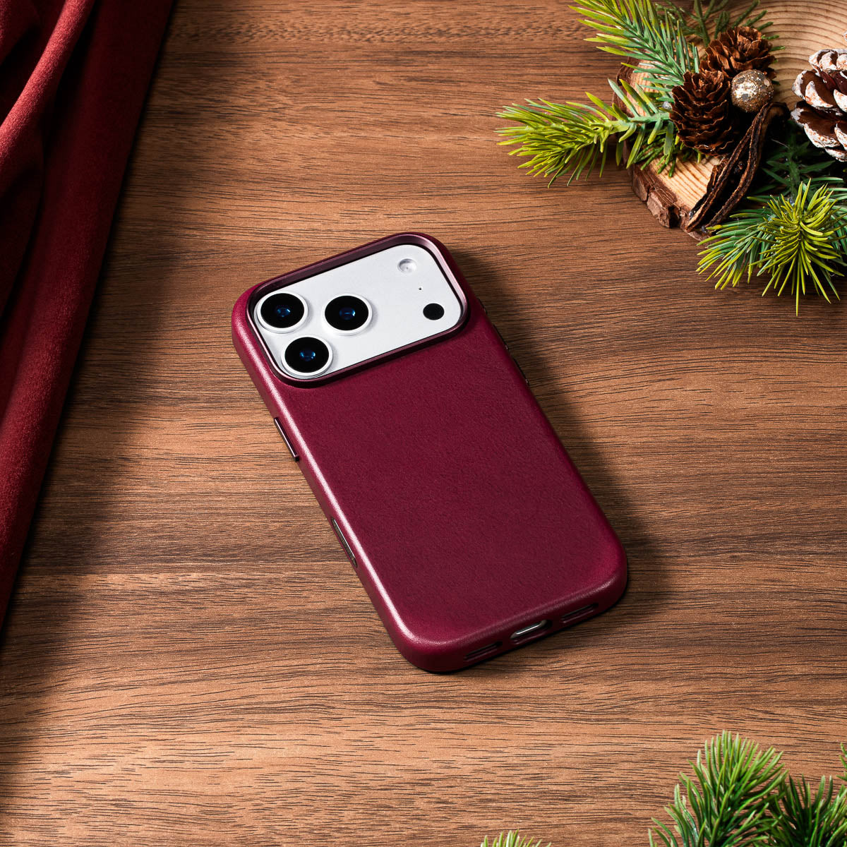 cherry vachetta leather case for iphone 18 pro lying flat on wooden desk