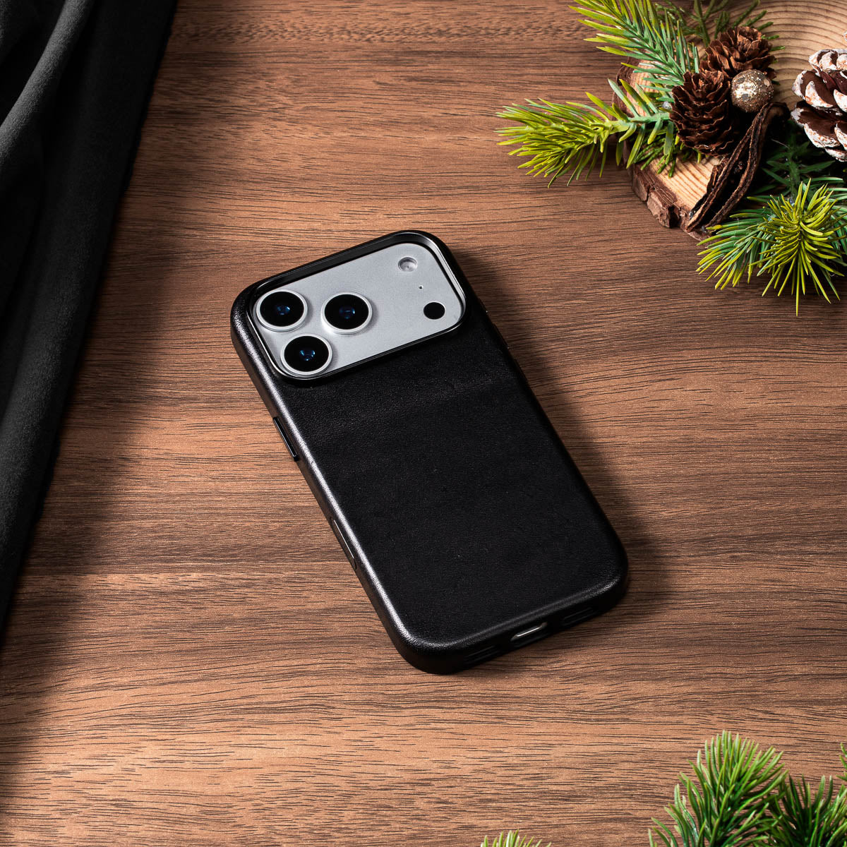 noir black vachetta leather case for iphone 18 pro lying flat on wooden desk