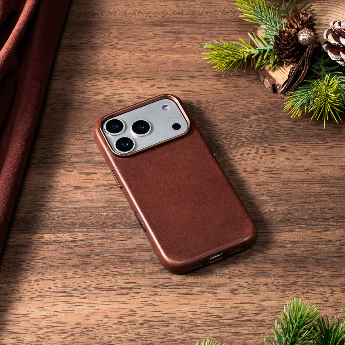 dark brown vachetta leather case for iphone 18 pro max lying flat on wooden desk
